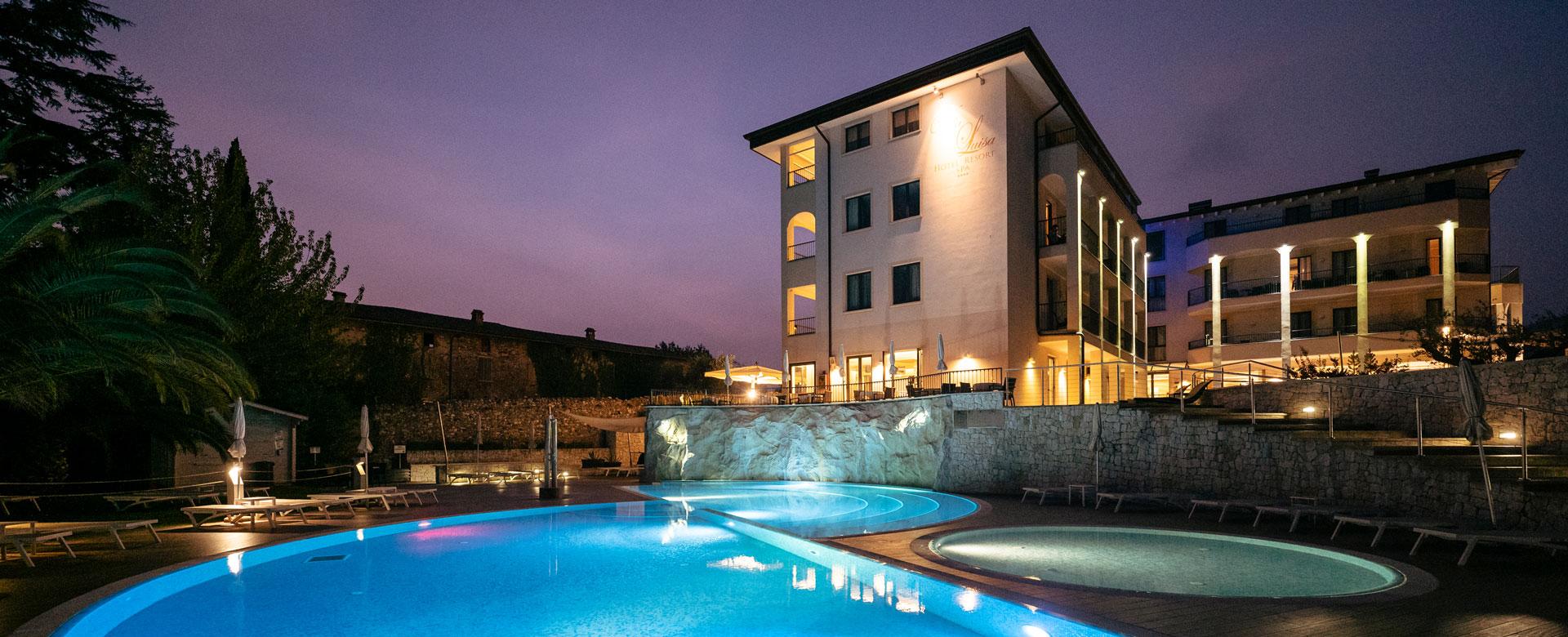 Piscina illuminata di sera, atmosfera rilassante e lussuosa.